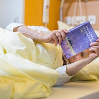 Patientin liest im Bett