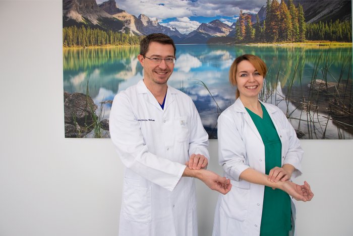 Prim. Priv.-Doz. Dr. Martin Martinek, MBA, und OÄ Dr.in Elisabeth Weilguny zeigen, wie man mit den Fingern am Handgelenk den eigenen Puls messen kann.